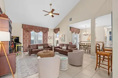 a living room with a couch and a table at Mickeys Sunrise - Phenomenal 7BR Themed Rooms Home Theater Swingset SplashPad Gas BBQ - 2 miles to Disney in Orlando