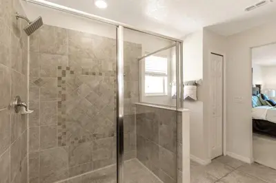 a bathroom with a shower with a glass door at 299- Fabulous 4 Bed Modern Decor Villa with Private Pool Overlooking Conservation and Water View in Kissimmee