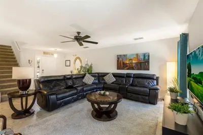 a living room with a leather couch and a table at 299- Fabulous 4 Bed Modern Decor Villa with Private Pool Overlooking Conservation and Water View in Kissimmee