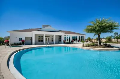 a large swimming pool in front of a house at Casa 3Q c/ Piscina de Resort e sala de jogos in Kissimmee