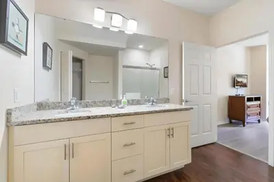 a bathroom with two sinks and a large mirror at Casa 3Q c/ Piscina de Resort e sala de jogos in Kissimmee