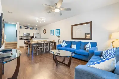 a living room with blue couches and a dining room at Casa 3Q c/ Piscina de Resort e sala de jogos in Kissimmee