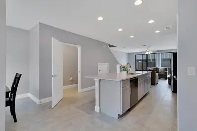 a kitchen with white cabinets and a counter top at Spectacular! Townhome 9 Miles to Disney World! in Kissimmee