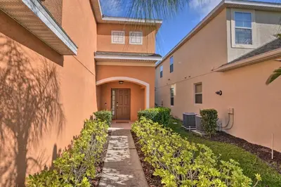 an orange building with a door and a sidewalk at Look over Nature, Pool Home Near Disney Parks in Kissimmee