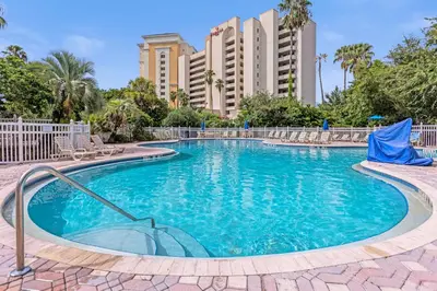 a swimming pool with chairs and buildings in the background at 14-Near Universal Studios Amazing View in Orlando