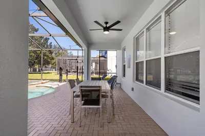 a patio with a table and chairs and a ceiling fan at 6Q Windsor Hills, Piscina Privativa + Game Room in Orlando