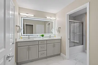 a bathroom with a sink and a mirror and a tub at 6Q Windsor Hills, Piscina Privativa + Game Room in Orlando