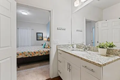 a bathroom with a sink and a bedroom with a bed at 3200- Aconchegante casa de 4 Quartos com Acesso ao resort, Próxima à Disney in Kissimmee