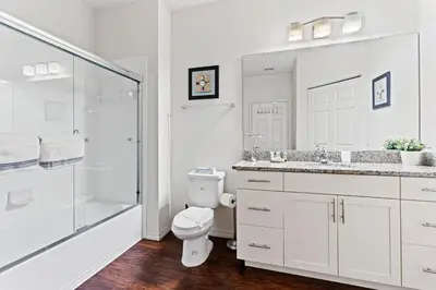 a white bathroom with a toilet and a shower at 3200- Aconchegante casa de 4 Quartos com Acesso ao resort, Próxima à Disney in Kissimmee