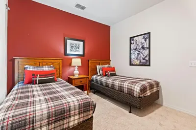 two beds in a room with red walls at 3200- Aconchegante casa de 4 Quartos com Acesso ao resort, Próxima à Disney in Kissimmee