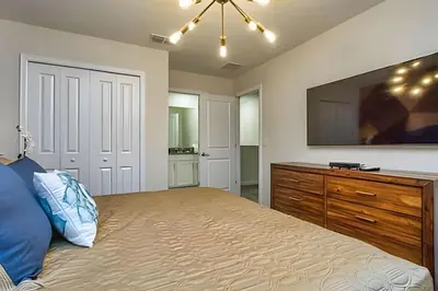 a bedroom with a bed with a dresser and a tv at Casa 7Q perto da Disney com Piscina e Games in Kissimmee