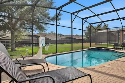 a swimming pool with chairs and a basketball hoop at Casa 6Q Familiar c/ Game Room Marvel e Piscina in Orlando