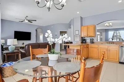 a kitchen and living room with a table and chairs at Casa 6Q Familiar c/ Game Room Marvel e Piscina in Orlando