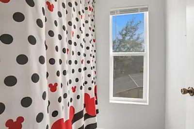a bathroom with a window and a shower curtain at Casa 6Q Familiar c/ Game Room Marvel e Piscina in Orlando