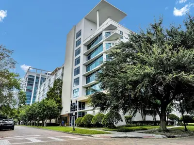 a white building with a tree in front of it at Extra Large 1 Bdrm Condo & Gym in Orlando