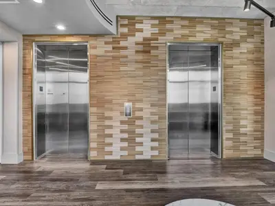 a lobby with three elevators in a brick wall at Extra Large 1 Bdrm Condo & Gym in Orlando