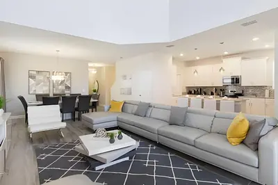 a living room with a couch and a kitchen at Casa Resort com Piscina Aquecida e Pingue-Pongue in Kissimmee