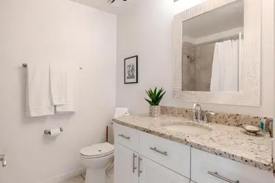 a bathroom with a sink and a toilet and a mirror at 3Q/2B Vista para o Lago c/piscina | 10min->Disney in Kissimmee