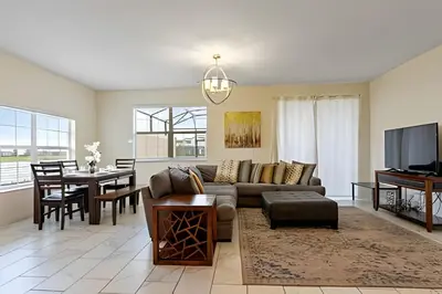 a living room with a couch and a dining room at Casa 5Q c/ Piscina – 10min da Disney + Resort in Kissimmee