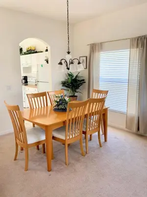 a dining room with a wooden table and chairs at Grand Cumbrian - Four Bedroom Home in Kissimmee
