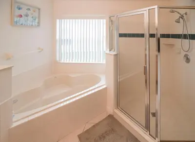 a white bathroom with a tub and a shower at Cumbrian Retreat in Kissimmee