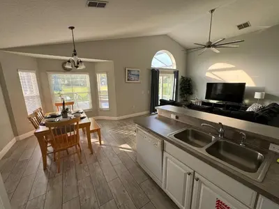 a kitchen and dining room with a table and a sink at Casablanca Villa in Kissimmee