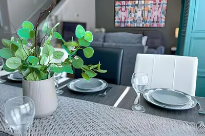 a dining room table with a vase of green plants at Casa 4Q perto da Disney c/ Resort e Padaria in Kissimmee
