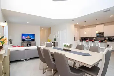 a dining room and kitchen with a table and chairs at Villa 5 Quartos com Piscina no Storey Lake in Kissimmee