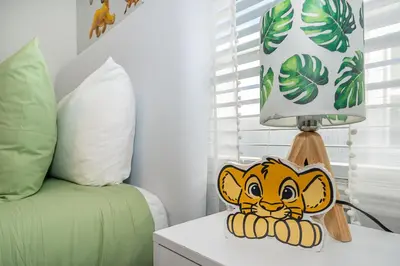 a lamp sitting on a table next to a bed at Epic Elegance Home Resort Amenities Disney10 miles in Kissimmee