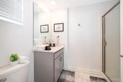 a white bathroom with a sink and a shower at Epic Elegance Home Resort Amenities Disney10 miles in Kissimmee
