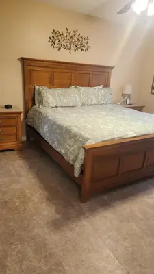 a bedroom with a large bed with a wooden headboard at Disney Area Condo at Laguna Bay Villas! in Kissimmee