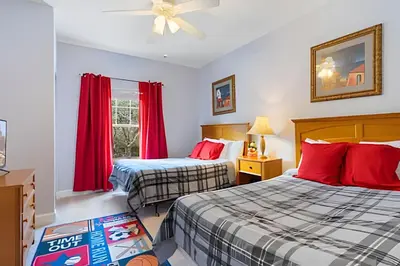 two beds in a room with red curtains at Casa Moderna 3Q – Perto da Disney in Kissimmee
