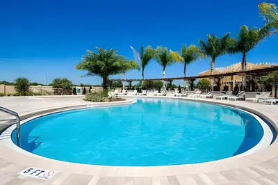 a swimming pool at a resort with palm trees at Casa Moderna 3Q – Perto da Disney in Kissimmee