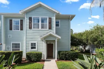 a white house with a brown door at Casa 4Q c/ Clubhouse – 10 Min da Disney in Kissimmee