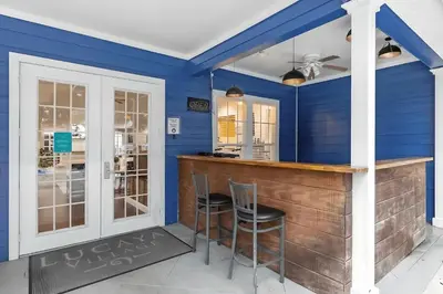 a blue room with a bar with two chairs at Casa 4Q c/ Clubhouse – 10 Min da Disney in Kissimmee