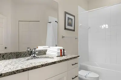 a white bathroom with a sink and a toilet at Casa 4Q c/ Piscina e Clubhouse — 10min da Disney in Kissimmee