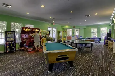 a man playing a game in a gaming room with pool tables at Windsor Palms Oasis Harry Potter Mickey Pool Spa in Kissimmee