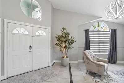 a living room with a white door and a chair at Fascinating Private Pool And Game-Room, Near Disney!! in Kissimmee