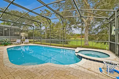 a swimming pool with a pergola next to a house at Splash, Play, with a Disney Stay in Orlando