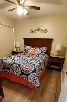 a bedroom with a bed with a colorful comforter at Laguna Bay Villas - Disney Area Condo in Kissimmee