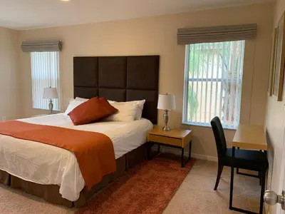 a bedroom with a large bed and a chair at Four Bedroom Townhouse in Regal Oaks at Old Town in Orlando