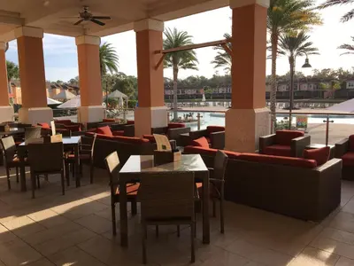 a restaurant with tables and chairs and a pool at Four Bedroom Townhouse in Regal Oaks at Old Town in Orlando