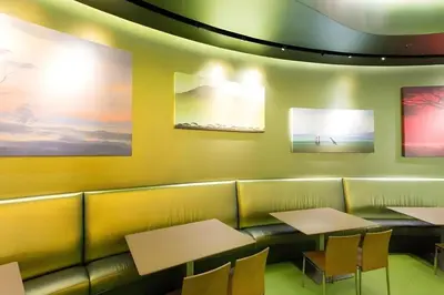 a restaurant with tables and chairs and paintings on the wall at Disney's Art Of Animation Resort in Orlando