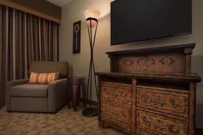 a living room with a chair and a television on a dresser at Disney's Animal Kingdom Villas - Jambo House in Orlando