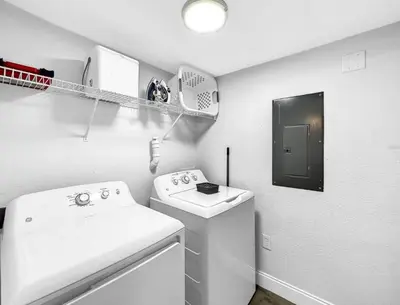a bathroom with a sink and a washing machine at Scenic 3BR Family Retreat, Pool, Gym, 3mi to Disney in Kissimmee