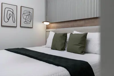 a bedroom with a large white bed with green pillows at BRAND Themed Luxury 5Bedrooms At Paradiso Grande in Orlando