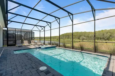 an indoor pool in a glass house with a view at Brand New Home 9 Bedrooms5 Baths At Storey Lake in Kissimmee