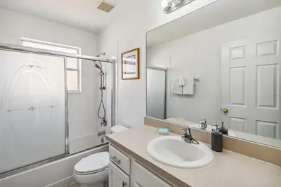 a white bathroom with a sink and a toilet at 765 Beautiful Vacation Home With Private Pool, And Much More!! in Kissimmee