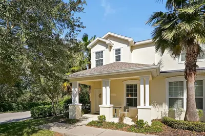 a white house with a palm tree at Family-Friendly home w/ Pool & Resort Perks Near Disney in Orlando
