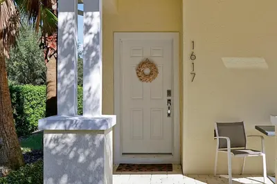 a white door on a house with a chair at Family-Friendly home w/ Pool & Resort Perks Near Disney in Orlando